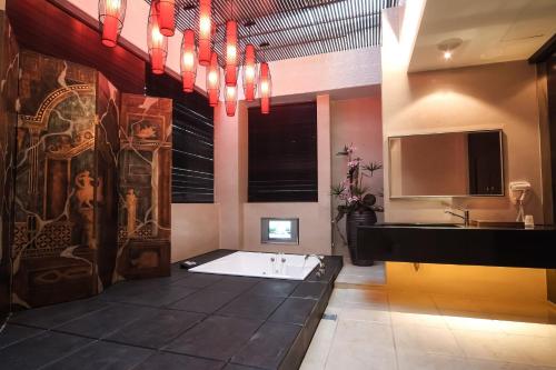 a bathroom with a bath tub and a sink at Xiadu Motel in Taichung