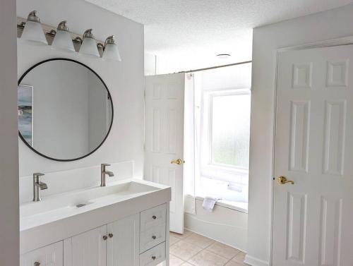 a white bathroom with a sink and a mirror at Be A Nomad - Lovely Neptune Beach 2bed, Monthly in Neptune Beach