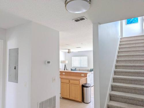 a hallway with a staircase and a sink in a house at Be A Nomad - Lovely Neptune Beach 2bed, Monthly in Neptune Beach