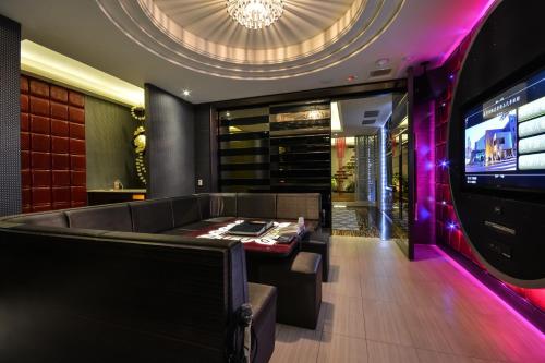 a bar with a couch and a tv in a room at Xiadu Motel in Taichung