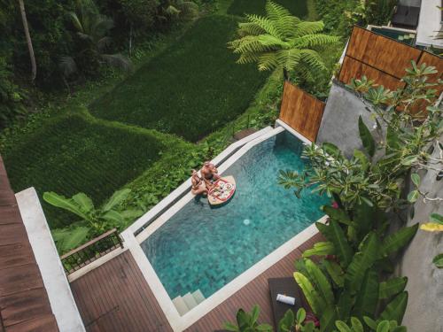 uma vista superior de um homem numa piscina em Dedary Resort Ubud by Ini Vie Hospitality em Ubud