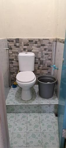 a bathroom with a toilet and a bath tub at Vallery homestay in Geruntang