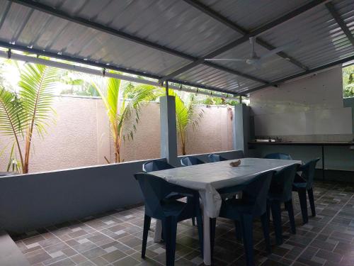 een eetkamer met een tafel en stoelen en palmbomen bij Villa Elyza in Rodrigues Island