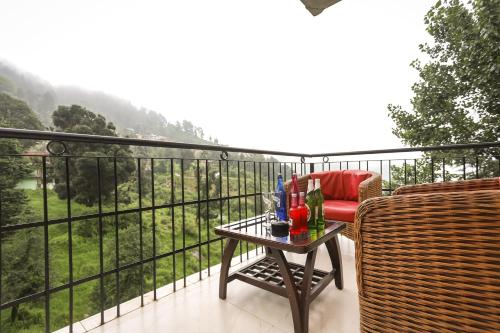 a balcony with a chair and a table with a view at Hotel Grand Nest in Dharamshala