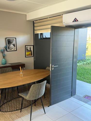 a dining room with a wooden table and a sliding door at Lakhe Lethu Apartment: Green Valley Estate in Nelspruit