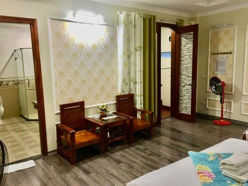 Cette chambre comprend un lit, une table et des chaises. dans l'établissement Ánh Dương Hostel - Ng 45 Võ Chí Công - by Bay Luxury, à Hanoï