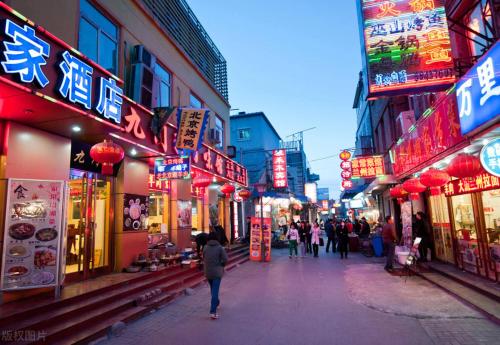 a group of people walking down a street with neon signs at Jingfang Building Boutique Smart Hotel - near Beijing Tiananmen Square,the Forbidden City,Wangfujing Street in Beijing