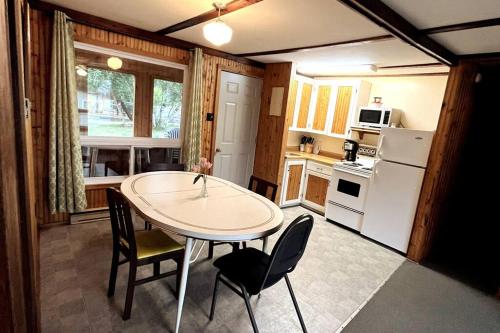 Betula Lake Resort في Seven Sister Falls: مطبخ مع طاولة وكراسي في غرفة
