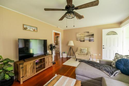 a living room with a flat screen tv and a ceiling fan at Hale Leilani - Hilo 3BR cold AC in Hilo
