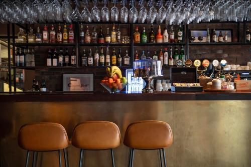 a bar with two chairs and a counter with drinks at Kviberg Park Hotel & Conference in Gothenburg