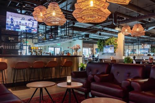 a bar with leather chairs and a bar counter at Kviberg Park Hotel & Conference in Gothenburg