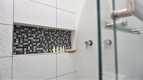 baño con ducha y puerta de cristal en APARTAMENTOS COMPLETOS Cama Queen a 10 min Aeropuerto Lima Per, en Lima