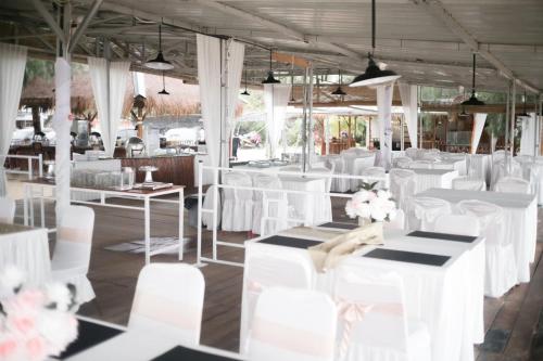 a room filled with white chairs and tables at Hello Bintan in Kangkakawal