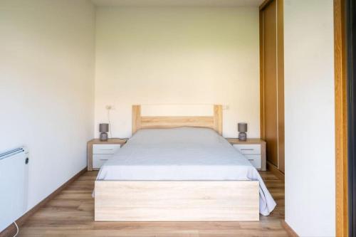 ein Schlafzimmer mit einem Bett und zwei Nachttischen in der Unterkunft Logement avec baignoire SPA Villa de luxe in Fonte Boa