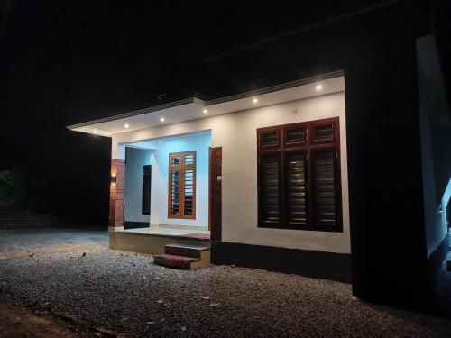 a small house is lit up at night at Eden Homestays in Wayanad