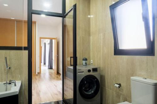 ein Badezimmer mit einer Waschmaschine und einem Waschbecken in der Unterkunft Logement avec baignoire SPA Villa de luxe in Fonte Boa