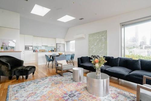 een woonkamer met een bank en een tafel bij Sydney Penthouse in Sydney