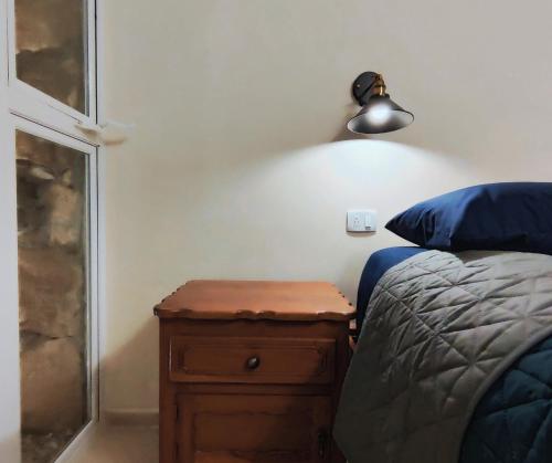 a bedroom with a bed and a wooden night stand at Casa Colibri Central Villa with Private Pool and Tub Merida in Mérida