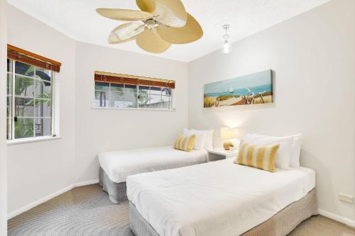 2 letti in una camera bianca con ventilatore a soffitto di Lotus Lakes - Resort Style Living a Cairns North
