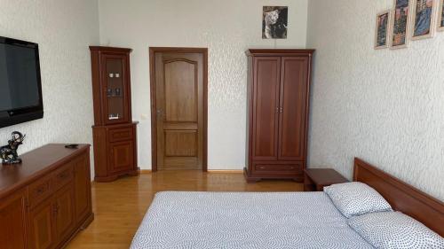 a bedroom with a bed and a flat screen tv at Comfortable apartment on the Obolon in Kyiv