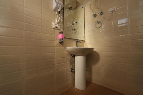 uma casa de banho com um lavatório e um espelho em Hotel Grand Nest em Dharamshala