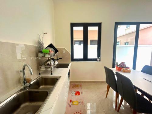 a kitchen with a sink and a table with chairs at Homestay CX 8 -129 in Hòa Bình