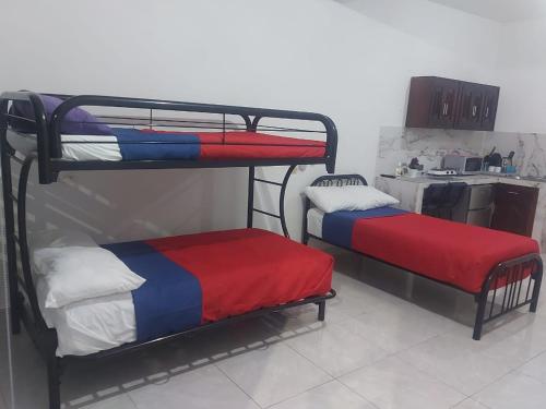 two bunk beds in a room with a kitchen at DEPARTAMENTO PERLITA in Mazatlán