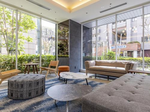 a living room with furniture and large windows at Tokyu Stay Nishi Shinjuku in Tokyo