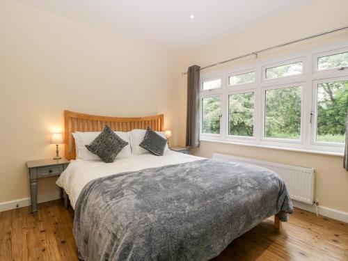 a bedroom with a large bed and two windows at Sherpa in Romsey