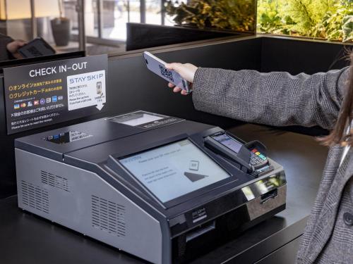 a person is holding a cash register at Tokyu Stay Nishi Shinjuku in Tokyo