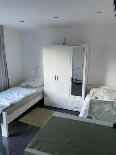 a bedroom with two beds and a white cabinet at Ferienwohnung mit Fußbodenheizung nahe Messe, gratis Parkplatz und Abstellplatz E - Bike in Hannover
