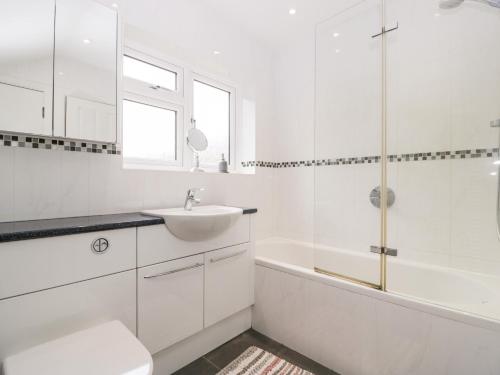 een witte badkamer met een wastafel, een bad en een toilet bij Sherpa in Romsey