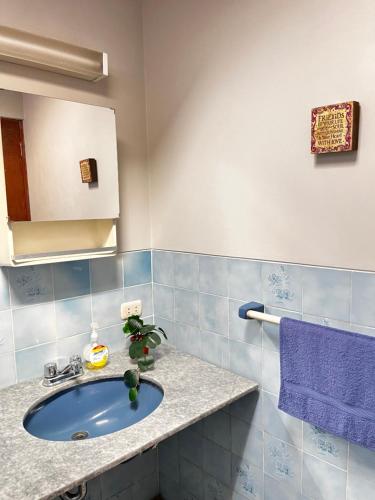 Yanahuara的住宿－T'ikary Wasi Hostel，一间带水槽和紫色毛巾的浴室