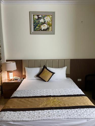 ein Schlafzimmer mit einem Bett mit einem Bild an der Wand in der Unterkunft Phước Thịnh Hostel - Ngõ 19 P. Nguyễn Văn Lộc, Hà Đông - by Bay Luxury in Hanoi