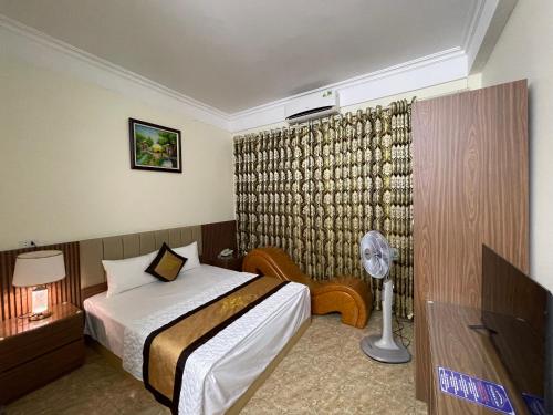 ein Hotelzimmer mit einem Bett und einem Ventilator in der Unterkunft Phước Thịnh Hostel - Ngõ 19 P. Nguyễn Văn Lộc, Hà Đông - by Bay Luxury in Hanoi