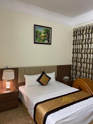 ein Hotelzimmer mit einem Bett und einem Bild an der Wand in der Unterkunft Phước Thịnh Hostel - Ngõ 19 P. Nguyễn Văn Lộc, Hà Đông - by Bay Luxury in Hanoi