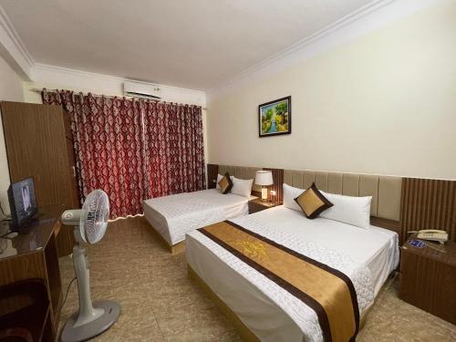 ein Hotelzimmer mit 2 Betten und einem Ventilator in der Unterkunft Phước Thịnh Hostel - Ngõ 19 P. Nguyễn Văn Lộc, Hà Đông - by Bay Luxury in Hanoi