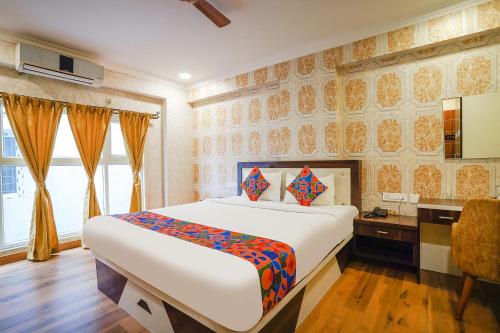 a bedroom with a large bed and a desk at FabHotel Prime Signature Inn in Bangalore