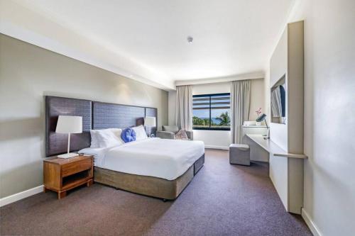 una camera d'albergo con un grande letto e una finestra di An Exceptional Seaside Esplanade Locale with Pool a Darwin