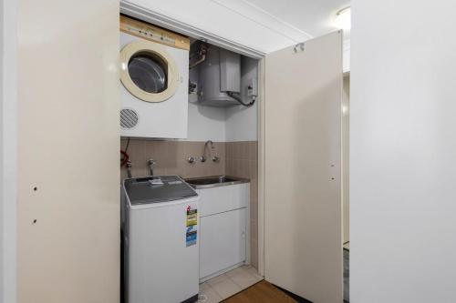 a small kitchen with a sink and a washing machine at Family Apartment close to Perth City in Perth