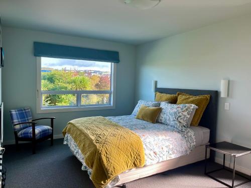 a bedroom with a bed and a large window at Punawai Homestay in Taupo