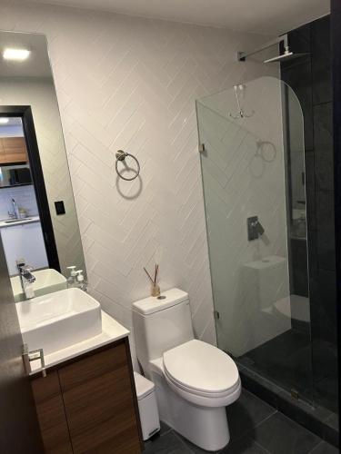 a bathroom with a toilet and a sink and a shower at Venecia 1BR Zona 10 Luxury Suite - Pool, Jacuzzi, Gym & View in Guatemala