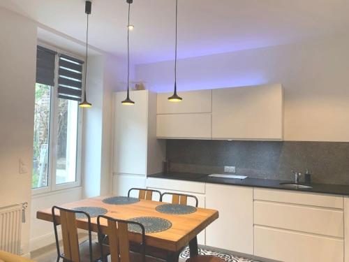 une cuisine avec une table en bois et quelques chaises dans l'établissement 2 chambres et une terrasse à Paris!, à Paris
