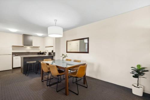a kitchen and dining room with a table and chairs at Spacious Holiday Apart on Hay St CBD in Perth