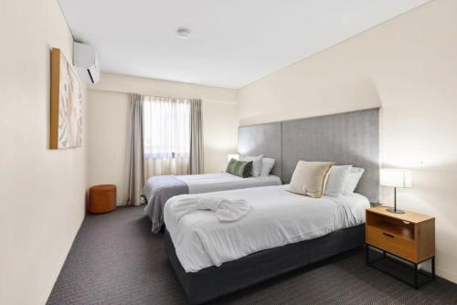 a hotel room with two beds and a window at Spacious Holiday Apart on Hay St CBD in Perth