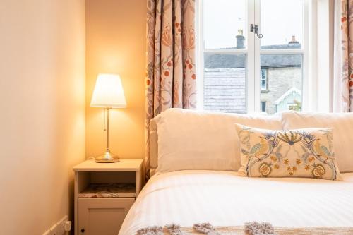 um quarto com uma cama e uma janela em Chimney Pots cottage em Youlgreave