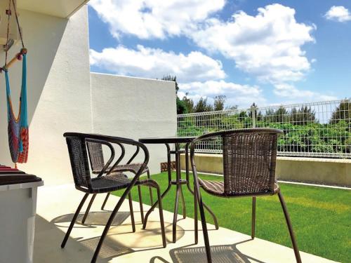 two chairs and a table on a patio at Churaumi Terrace in Motobu