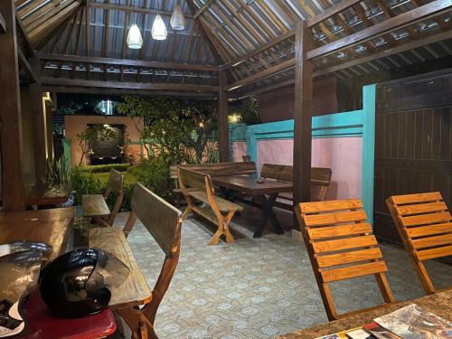 a patio with a table and chairs and a dining room at Semilir Inn Senggigi in Senggigi