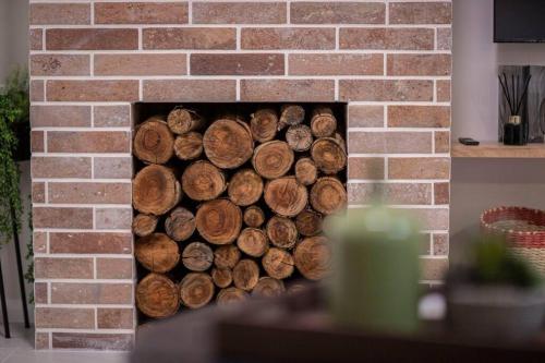 a stack of logs in a brick fireplace at Stunning Northbridge Townhouse W Off St Parking in Perth