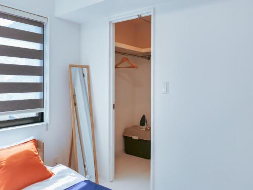 Schlafzimmer mit einer Tür, die zu einem Schrank führt in der Unterkunft 2023 Open Shinjuku Okubo 5mins to 2stns 200M WIFI in Tokio